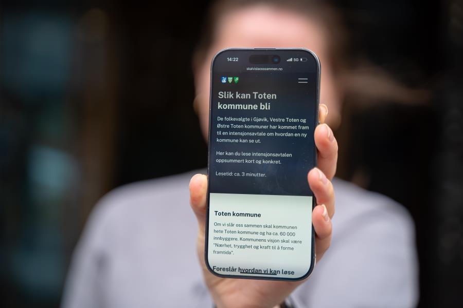 Bilde av person som holder en mobiltelefon med tekst gjeldende deltakelse av kommunesammenslåing